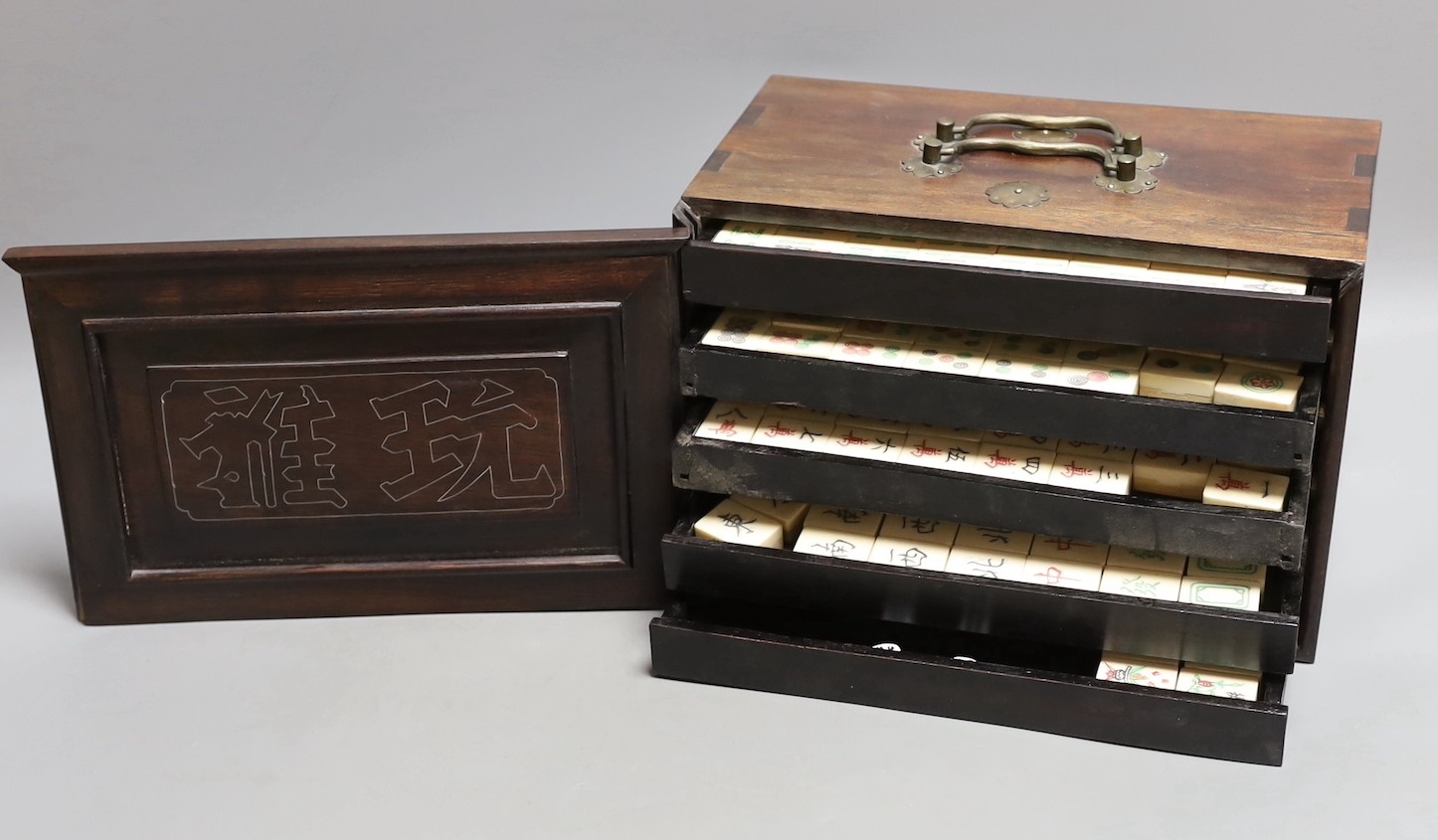 A Chinese boxed mahjong set, bone and bamboo gaming pieces, 24.5 cms wide x 16cms high.